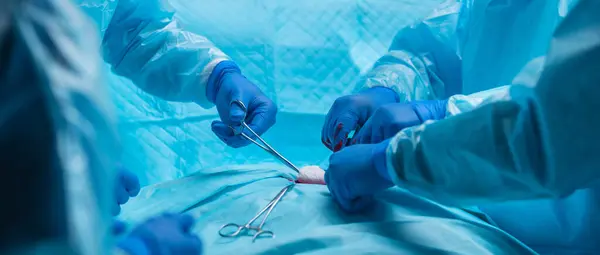 多样化的专业医生团队使用高科技设备和技术 在现代手术室进行外科手术 外科医生正在努力抢救医院里的病人 卫生和科学概念 免版税图库照片