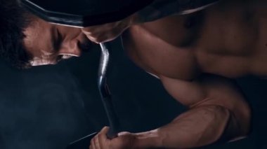 Siyah arka planda formda ve sportif vücut geliştirici. Halter kullanarak vücut geliştirici eğitimi. Spor ve spor kavramları. Dikey video.