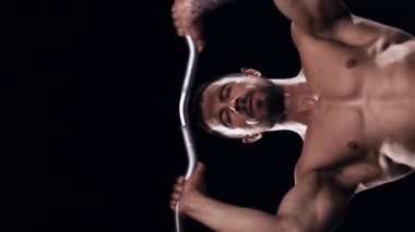 Siyah arka planda formda ve sportif vücut geliştirici. Halter kullanarak vücut geliştirici eğitimi. Spor ve spor kavramları. Dikey video.