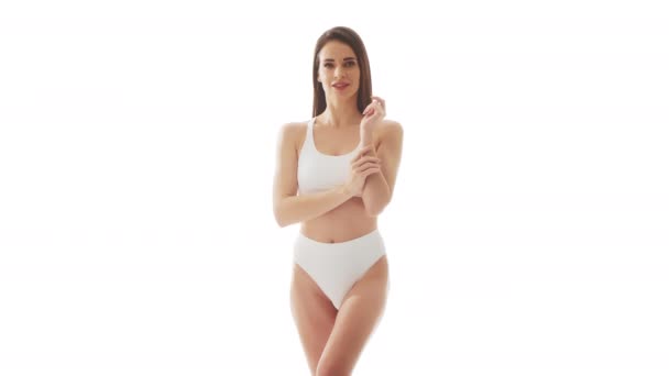 漂亮的女人穿着白色内裤 背景是孤立的白色 演播室录象 关于身穿泳衣的健康少女 健康和皮肤护理 节食和化妆品的概念 — 图库视频影像