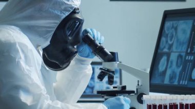 Laboratuvar ekipmanları, mikroskoplar ve test tüpleri kullanarak araştırma laboratuarında çalışan koruyucu giysi ve maskeler giyen bilim adamları. Tıp, sağlık ve teknoloji kavramı.