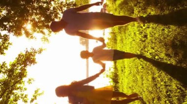 Deniz kenarında mutlu bir aile. Kırsal kesimde tarla ve ağaçlar. Gün batımının ya da güneşin sıcacık renkleri. Sevgi dolu ebeveynler ve güzel çocuklar. Aşk ve ebeveynlik kavramı.