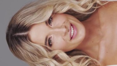 Gri arka planda genç ve güzel sarışın kadının stüdyo portresi. Cilt bakımı ve sağlık kavramı.