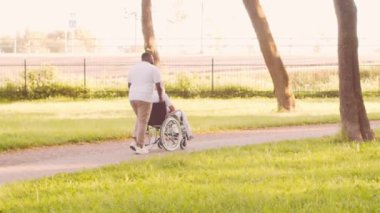 Afro-Amerikalı bakıcı ve yaşlı adam. Bakımevindeki profesyonel hemşire ve hastası. Yardım, rehabilitasyon ve sağlık hizmetleri kavramı.