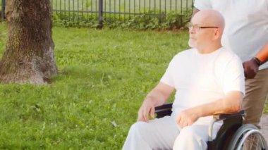 Afro-Amerikalı bakıcı ve yaşlı adam. Bakımevindeki profesyonel hemşire ve hastası. Yardım, rehabilitasyon ve sağlık hizmetleri kavramı.