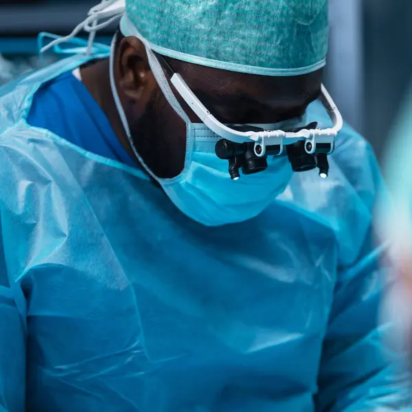 多样化的专业医生团队使用高科技设备和技术 在现代手术室进行外科手术 医生们正在努力抢救医院里的病人 免版税图库图片