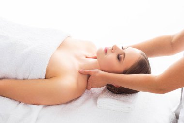 Beyaz arka planda masaj yaptıran genç bir kadın. Spa, sağlık ve dinlenme konsepti.