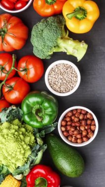 Dikey video. Sağlıklı yiyecekler: taze sebzeler, meyveler ve süper yiyecekler. Beslenme, diyet, vejetaryen gıda konsepti. Siyah arkaplan