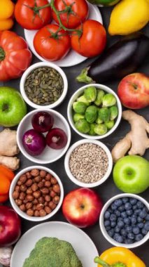 Dikey video. Sağlıklı yiyecekler: taze sebzeler, meyveler ve süper yiyecekler. Beslenme, diyet, vejetaryen gıda konsepti. Siyah arkaplan