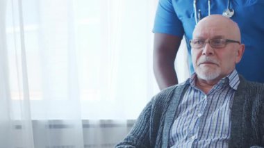 Afro-Amerikalı bakıcı ve yaşlı adam. Bakımevindeki profesyonel hemşire ve hastası. Yardım, rehabilitasyon ve sağlık hizmetleri kavramı.