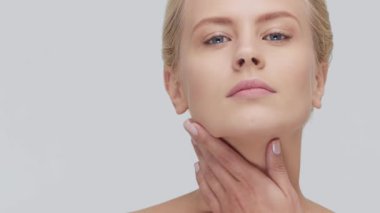 Cilt bakımı kremi süren genç, güzel ve doğal sarışın kadının stüdyo portresi. Yüz gerdirme, kozmetik ve makyaj konsepti.