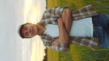 Günbatımı tarımının önündeki çiftçi. Kırsal kesimde bir adam. Kır hayatı, gıda üretimi, tarım ve kırsal yaşam tarzı kavramı.