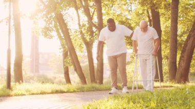 Afro-Amerikalı bakıcı ve yaşlı adam. Bakımevindeki profesyonel hemşire ve hastası. Yardım, rehabilitasyon ve sağlık hizmetleri kavramı.