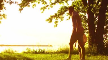 Deniz kenarında mutlu bir aile. Kırsal kesimde tarla ve ağaçlar. Gün batımının ya da güneşin sıcacık renkleri. Sevgi dolu ebeveynler ve güzel çocuklar. Aşk ve ebeveynlik kavramı.