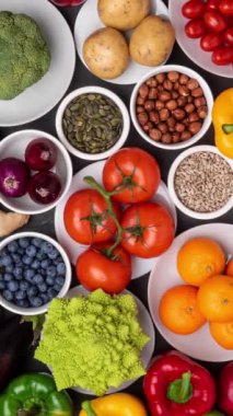 Dikey video. Sağlıklı yiyecekler: taze sebzeler, meyveler ve süper yiyecekler. Beslenme, diyet, vejetaryen gıda konsepti. Siyah arkaplan