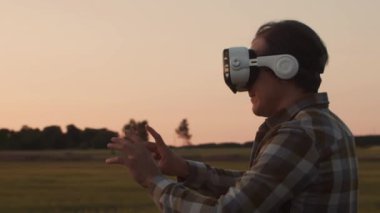 Günbatımı tarımının önündeki çiftçi. Kırsal kesimde bir adam. Kır hayatı, gıda üretimi, tarım ve kırsal yaşam tarzı kavramı.