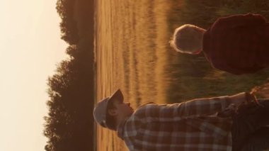 Çiftçi ve oğlu tarım arazisinde yürüyor. Kırsalda bir adam ve bir çocuk. Babalık kavramı, köy hayatı, tarım ve kırsal yaşam tarzı..