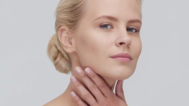 Cilt bakımı kremi süren genç, güzel ve doğal sarışın kadının stüdyo portresi. Yüz gerdirme, kozmetik ve makyaj konsepti.