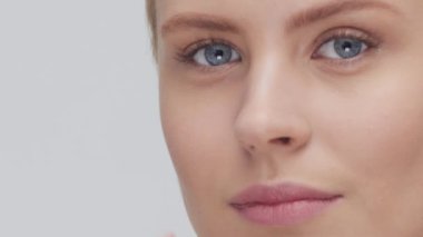 Cilt bakımı kremi süren genç, güzel ve doğal sarışın kadının stüdyo portresi. Yüz gerdirme, kozmetik ve makyaj konsepti.