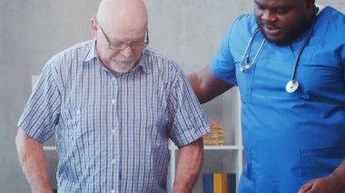Afro-Amerikalı bakıcı ve yaşlı adam. Bakımevindeki profesyonel hemşire ve hastası. Yardım, rehabilitasyon ve sağlık hizmetleri kavramı.
