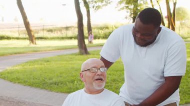 Afro-Amerikalı bakıcı ve yaşlı adam. Bakımevindeki profesyonel hemşire ve hastası. Yardım, rehabilitasyon ve sağlık hizmetleri kavramı.