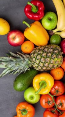 Dikey video. Sağlıklı yiyecekler: taze sebzeler, meyveler ve süper yiyecekler. Beslenme, diyet, vejetaryen gıda konsepti. Siyah arkaplan