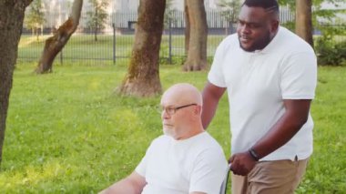 Afro-Amerikalı bakıcı ve yaşlı adam. Bakımevindeki profesyonel hemşire ve hastası. Yardım, rehabilitasyon ve sağlık hizmetleri kavramı.