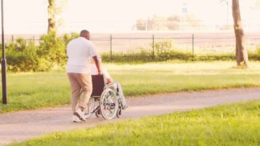 Afro-Amerikalı bakıcı ve yaşlı adam. Bakımevindeki profesyonel hemşire ve hastası. Yardım, rehabilitasyon ve sağlık hizmetleri kavramı.