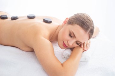 Beyaz arka planda masaj yaptıran genç bir kadın. Spa, sağlık ve dinlenme konsepti.