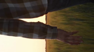 Günbatımı tarımının önündeki çiftçi. Kırsal kesimde bir adam. Kır hayatı, gıda üretimi, tarım ve kırsal yaşam tarzı kavramı.