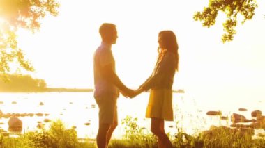 Deniz kenarında mutlu bir çift. Kırsal kesimde tarla ve ağaçlar. Gün batımının ya da güneşin sıcacık renkleri. Aşık bir adam ve kadın. Yaşam tarzı kavramı.