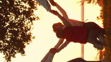 Aile gün batımında kırsalda yürür. Aşk kavramı, aile bakımı ve çocuklar. Dikey video.