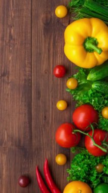 Dikey video. Sağlıklı yiyecekler: taze sebzeler, meyveler ve süper yiyecekler. Beslenme, diyet, vejetaryen gıda konsepti. Ahşap arkaplan