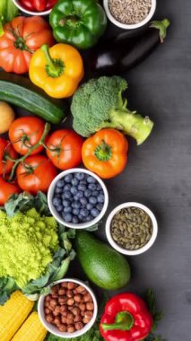 Dikey video. Sağlıklı yiyecekler: taze sebzeler, meyveler ve süper yiyecekler. Beslenme, diyet, vejetaryen gıda konsepti. Siyah arkaplan