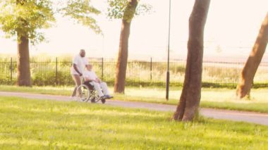 Afro-Amerikalı bakıcı ve yaşlı adam. Bakımevindeki profesyonel hemşire ve hastası. Yardım, rehabilitasyon ve sağlık hizmetleri kavramı.