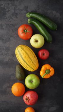 Dikey video. Sağlıklı yiyecekler: taze sebzeler, meyveler ve süper yiyecekler. Beslenme, diyet, vejetaryen gıda konsepti. Siyah arkaplan