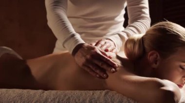 Kadın terapistten masaj tedavisi görüyor. Spa 'da masaj prosedürü. Sağlık, rahatlama, gençleşme ve sağIık kavramı.