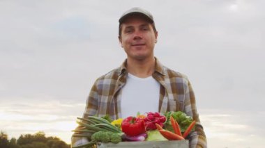 Günbatımı tarımının önündeki çiftçi. Kırsal kesimde bir adam. Kır hayatı, gıda üretimi, tarım ve kırsal yaşam tarzı kavramı.