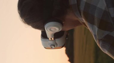 Günbatımı tarımının önündeki çiftçi. Kırsal kesimde bir adam. Kır hayatı, gıda üretimi, tarım ve kırsal yaşam tarzı kavramı.