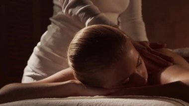 Kadın terapistten masaj tedavisi görüyor. Spa 'da masaj prosedürü. Sağlık, rahatlama, gençleşme ve sağIık kavramı.