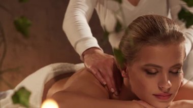 Kadın terapistten masaj tedavisi görüyor. Spa 'da masaj prosedürü. Sağlık, rahatlama, gençleşme ve sağIık kavramı.
