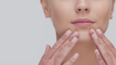 Cilt bakımı kremi süren genç, güzel ve doğal sarışın kadının stüdyo portresi. Yüz gerdirme, kozmetik ve makyaj konsepti.