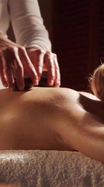 Kadın terapistten masaj tedavisi görüyor. Spa 'da masaj prosedürü. Sağlık, rahatlama, gençleşme ve sağIık kavramı.