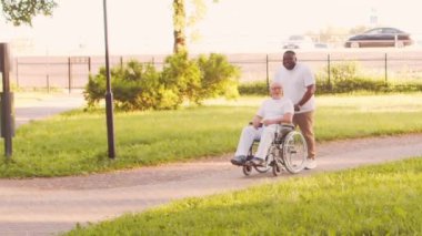 Afro-Amerikalı bakıcı ve yaşlı adam. Bakımevindeki profesyonel hemşire ve hastası. Yardım, rehabilitasyon ve sağlık hizmetleri kavramı.