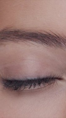 Cilt bakımı kremi süren genç, güzel ve doğal kızıl saçlı kadının stüdyo portresi. Yüz gerdirme, kozmetik ve makyaj konsepti. Dikey video.