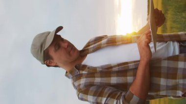 Farmer in front of a sunset agricultural landscape. Man in a countryside field. The concept of country life, food production, farming and country lifestyle.