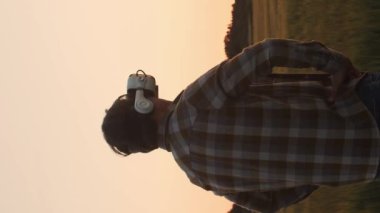 Farmer in front of a sunset agricultural landscape. Man in a countryside field. The concept of country life, food production, farming and country lifestyle.
