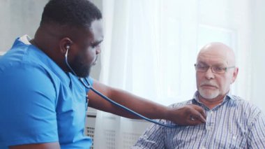 Afro-Amerikalı bakıcı ve yaşlı adam. Bakımevindeki profesyonel hemşire ve hastası. Yardım, rehabilitasyon ve sağlık hizmetleri kavramı.
