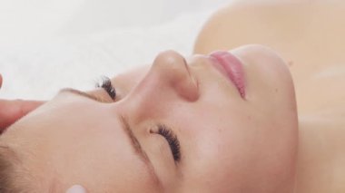 Kadın terapistten masaj tedavisi görüyor. Spa 'da masaj prosedürü. Sağlık, rahatlama, gençleşme ve sağIık kavramı.