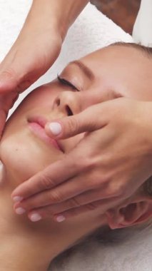 Kadın terapistten masaj tedavisi görüyor. Spa 'da masaj prosedürü. Sağlık, rahatlama, gençleşme ve sağIık kavramı.